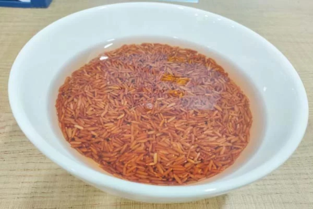 Ngâm gạo lứt đỏ với nước ấm để giúp hạt gạo được dẻo